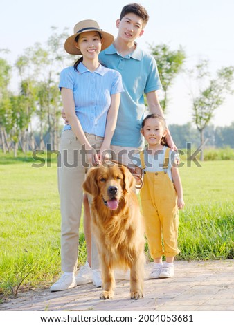 Happy family of three and pet dog in the park high quality photo