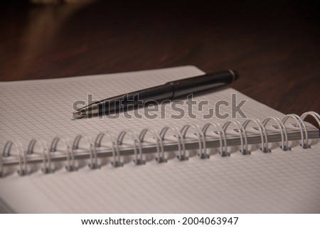 notepad next to pen on wooden table
