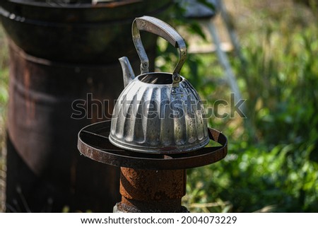 A stainless steel kettle on an outdoor "rocket" oven. How to survive in difficult times.