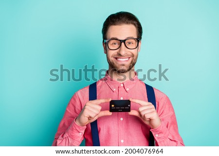 Photo of young business man happy positive smile demonstrate bank plastic card isolated over teal color background