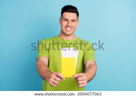 Photo of positive happy cheerful man hold hands tickets passport give young isolated on green color background