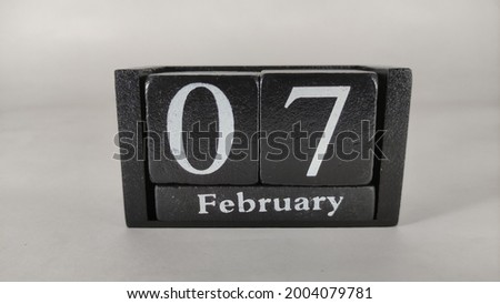 7th February written on black wood block.