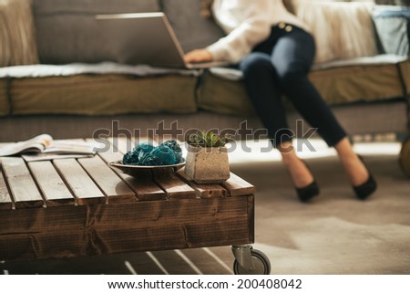 Closeup on coffee table and young woman using laptop in background Royalty-Free Stock Photo #200408042