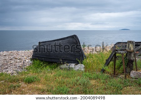 An old wooden boat on the seashore. Picture from the Baltic Sea. Blue sky and ocean in the background.