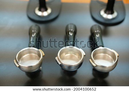 portafilter and tamper on counter bar at cafe. espresso tamping for coffee machine Royalty-Free Stock Photo #2004100652