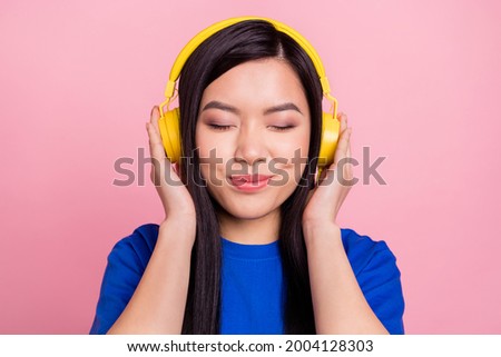 Photo of young joyful calm pretty woman listen music headphones good mood isolated on pink color background