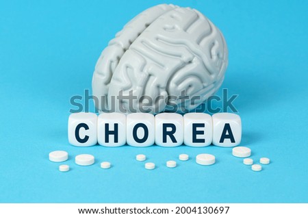 Medicine and health. Cubes lie on the table among the pills and imitation of the brain. The text on the dice - CHOREA