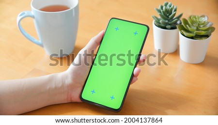 asian woman use green screen smartphone in coffee shop
