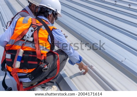 Two enginees are discussing how to repair metail roof sheet and Inspection damaged of metal roof sheet  Royalty-Free Stock Photo #2004171614