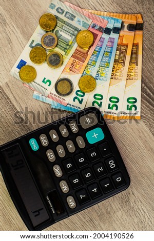 euro money of different denominations and calculator on wooden background
