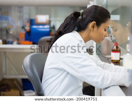 Closeup portrait, tired young woman scientist,crashing, with failed experiments and working long hours, leaning head against glass fume hood with mirror reflection. Isolated laboratory background Royalty-Free Stock Photo #200419751