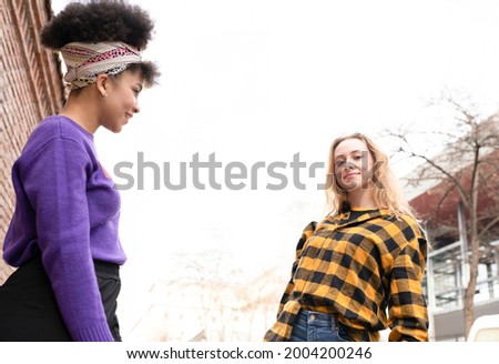 two beautiful African and Caucasian women, with gay pride flag