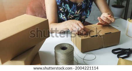 small online business owner packing parcel box at home to deliver product to customer. banner