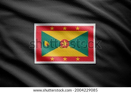 Grenada flag isolated on black jersey. National symbols of Grenada.