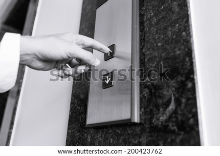 Business man pressing elevator button.