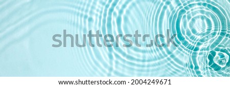 Blue water texture, blue mint water surface with rings and ripples. Spa concept background. Flat lay, copy space. Royalty-Free Stock Photo #2004249671