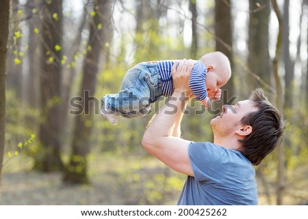 Happy middle age man holding his little baby 