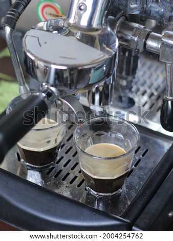 Close up image of espresso dripping machine with two small glass