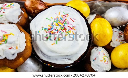easter cakes decorated with jam. next to them are painted eggs of natural colors. background easter