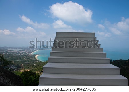 White staircase for tourists to take photos with nature, sky and beach from high angle at one of the beautiful viewpoints of Koh Samui. which overlooks the beach in a heart shape