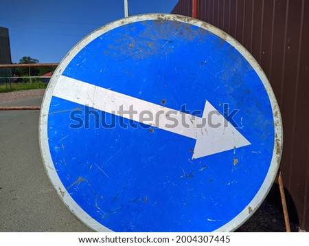 temporary road sign white arrow on a blue background pointing diagonally to the right.