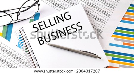 Notebook with text SELLING BUSINESS . Diagram and white background,Business concept