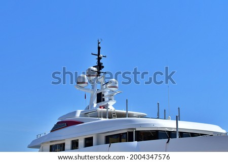 Upper deck of modern marine yacht with radar equipment against blue sky Royalty-Free Stock Photo #2004347576