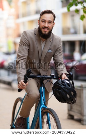 Cheerful businessman rides a bicycle to work. Eco friendly urban transport.