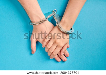 Male and female hands in handcuffs. Love forever. Prenuptial agreement, duties of love couple. Royalty-Free Stock Photo #2004393701