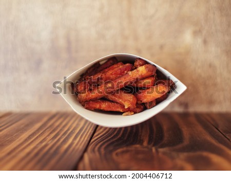 Carrot fries in a cardboard box. Vegetarian fast food dish. Grilled vegetables. BBQ cooking concept for people who do not eat