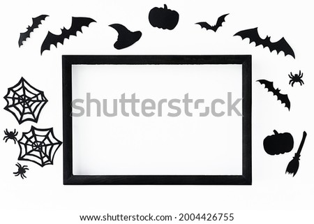 Halloween background with black frame and black paper accessories for holiday on a gray surface