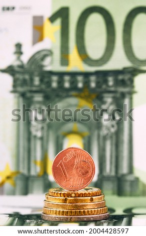 1 Euro cent against 100 Euro banknote, coins and banknotes of the single European currency. Money background.