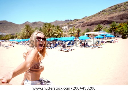 Beautiful happy woman enjoying sunny vacation day on the beach. Island summer vibes. Smiling girl having fun.