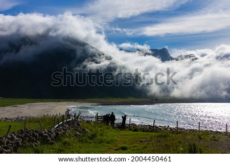 Stunning of white clouded roll over the mountain and the sea nearby the beach, stunning nature over the beach at Lofoten, Norway