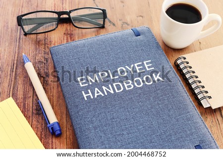 Concept image of employee handbook over wooden office table. top view Royalty-Free Stock Photo #2004468752