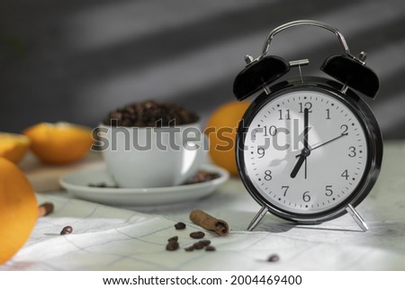 The retro alarm clock indicates 7:00 am and is illuminated by rays of morning light through the blinds. Background with copy space