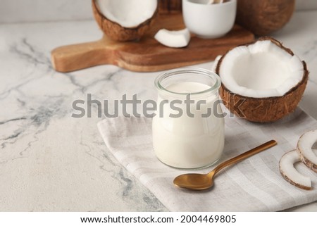 Jar of tasty coconut yogurt on light background Royalty-Free Stock Photo #2004469805