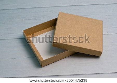 Empty gift box on a light wooden table. The concept of a gift for the holiday, what to give
