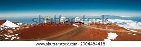 Astronomical research Keck Observatories on top of Mauna Kea mountain peak on Big Island of Hawaii, United States with deep blue sky and volcanic landscape. High resolution panoramic photo.