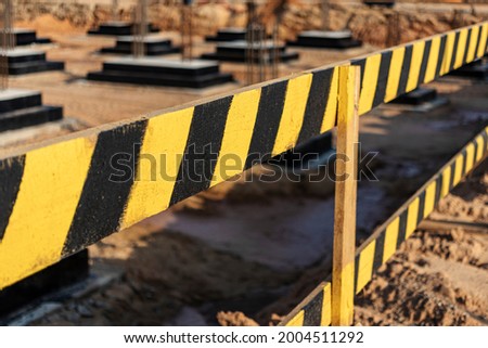 Construction pit fencing. Construction safety. Construction site with reinforced concrete foundations with protective fencing