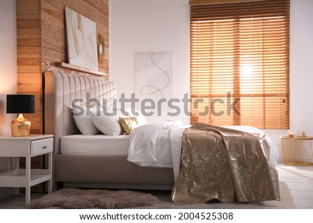Comfortable bed with stylish white linens indoors