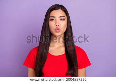 Photo of shiny flirty woman dressed red t-shirt sending you kiss isolated purple color background