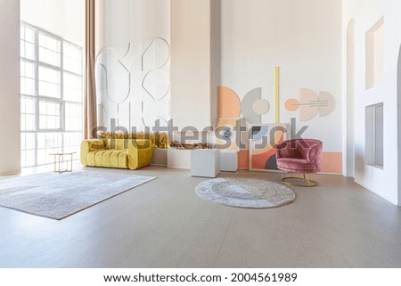 modern open-plan room interior in futuristic style in pastel colors with graphic wall decoration. very high ceilings and a huge window. soft stylish furniture with gold metallic elements Royalty-Free Stock Photo #2004561989