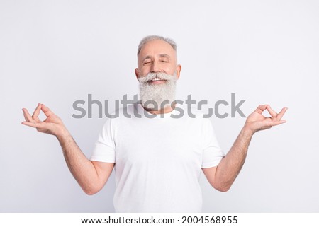 Portrait of positive grey hair beard old man crossed fingers wear white t-shirt isolated on grey color background