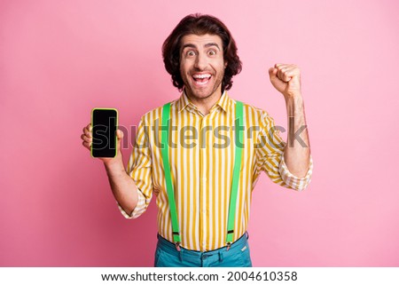 Photo of young excited man happy positive smile celebrate win victory smartphone fists hand isolated over pastel color background