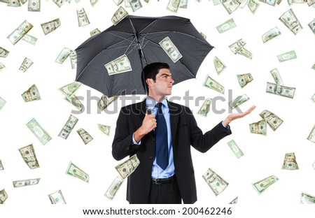 Stock image of businessman with umbrella and falling money