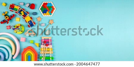 Baby kids toys on light blue background. Colorful educational wooden and musical toys. Top view, flat lay Royalty-Free Stock Photo #2004647477