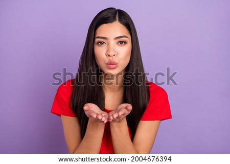Photo of flirty young lady blow kiss wear red t-shirt isolated on violet color background