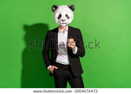Photo of confident agent guy hold coffee cup wear panda head black tuxedo isolated on green color background