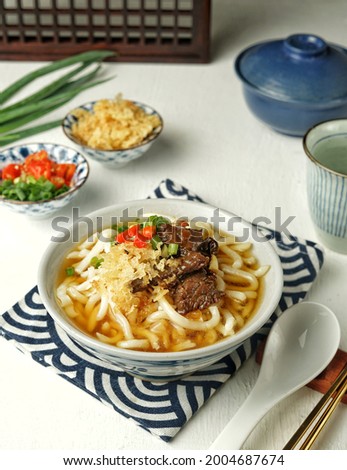 Homemade Niku Udon, udon noodle soup with the beef topping, tenkasu and sliced scallions. Japanese Food.